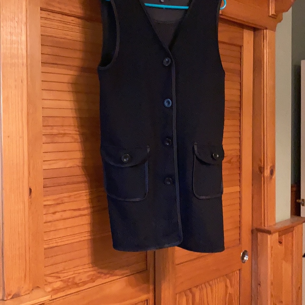 Long button down black vest with 2 front pockets.